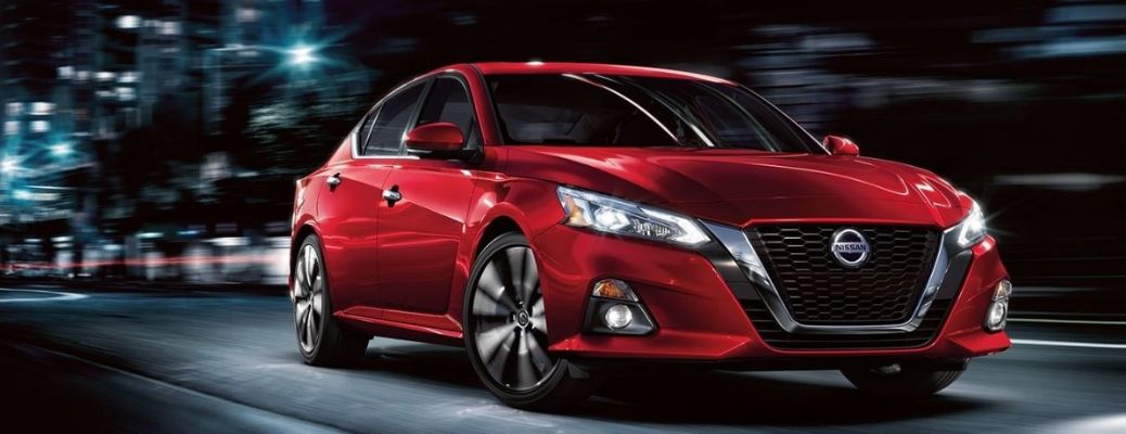 One red color car is running on the road at night.